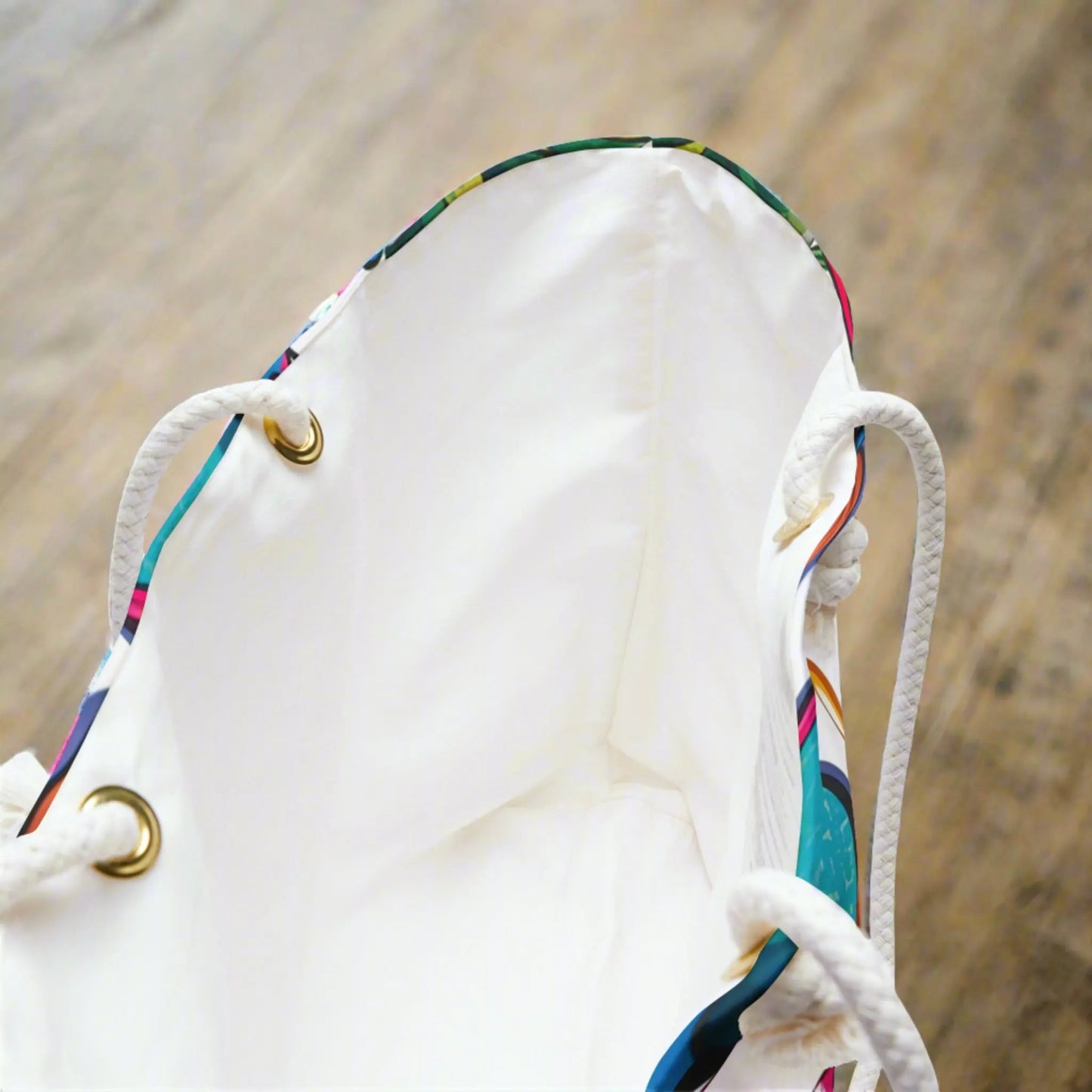 Showing the inside of a weekender tote with a white inside and rope handles with metal grommets