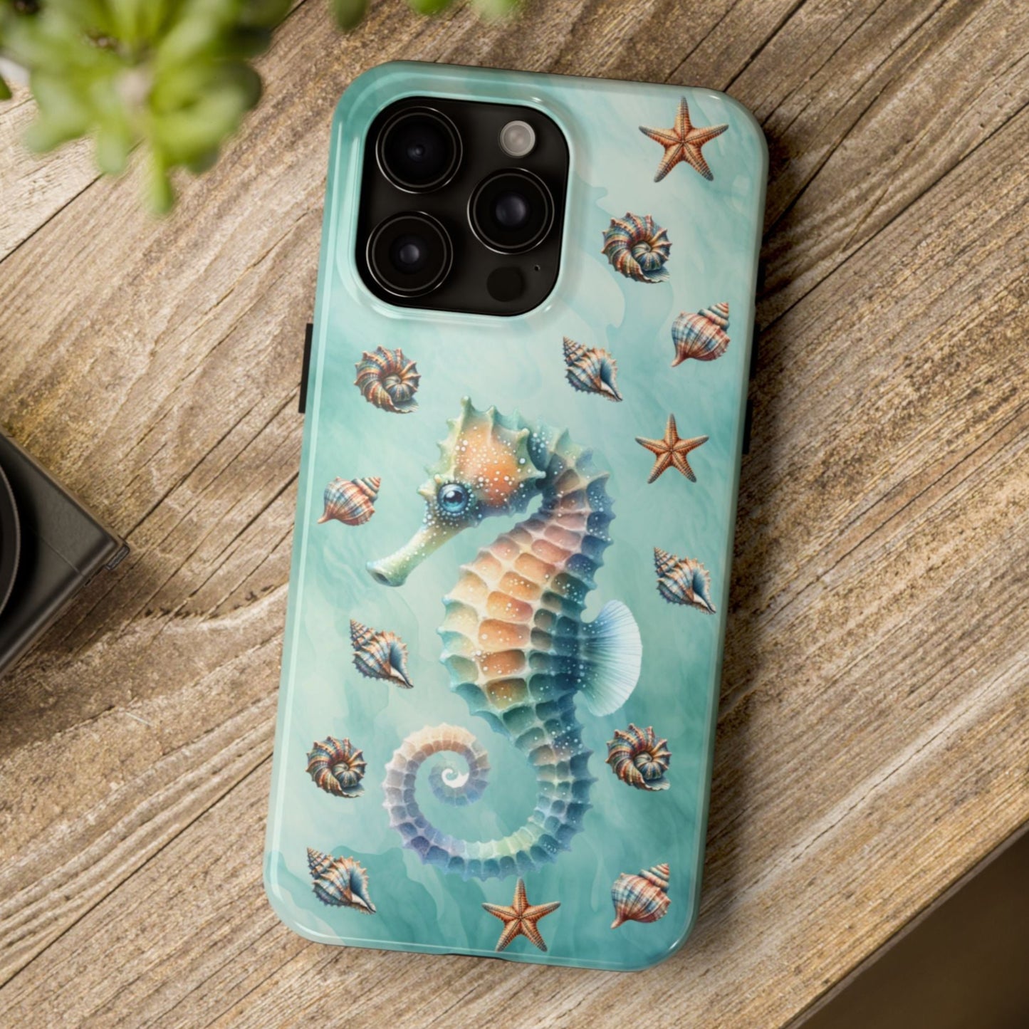 Phone case with seahorse design on a wooden surface