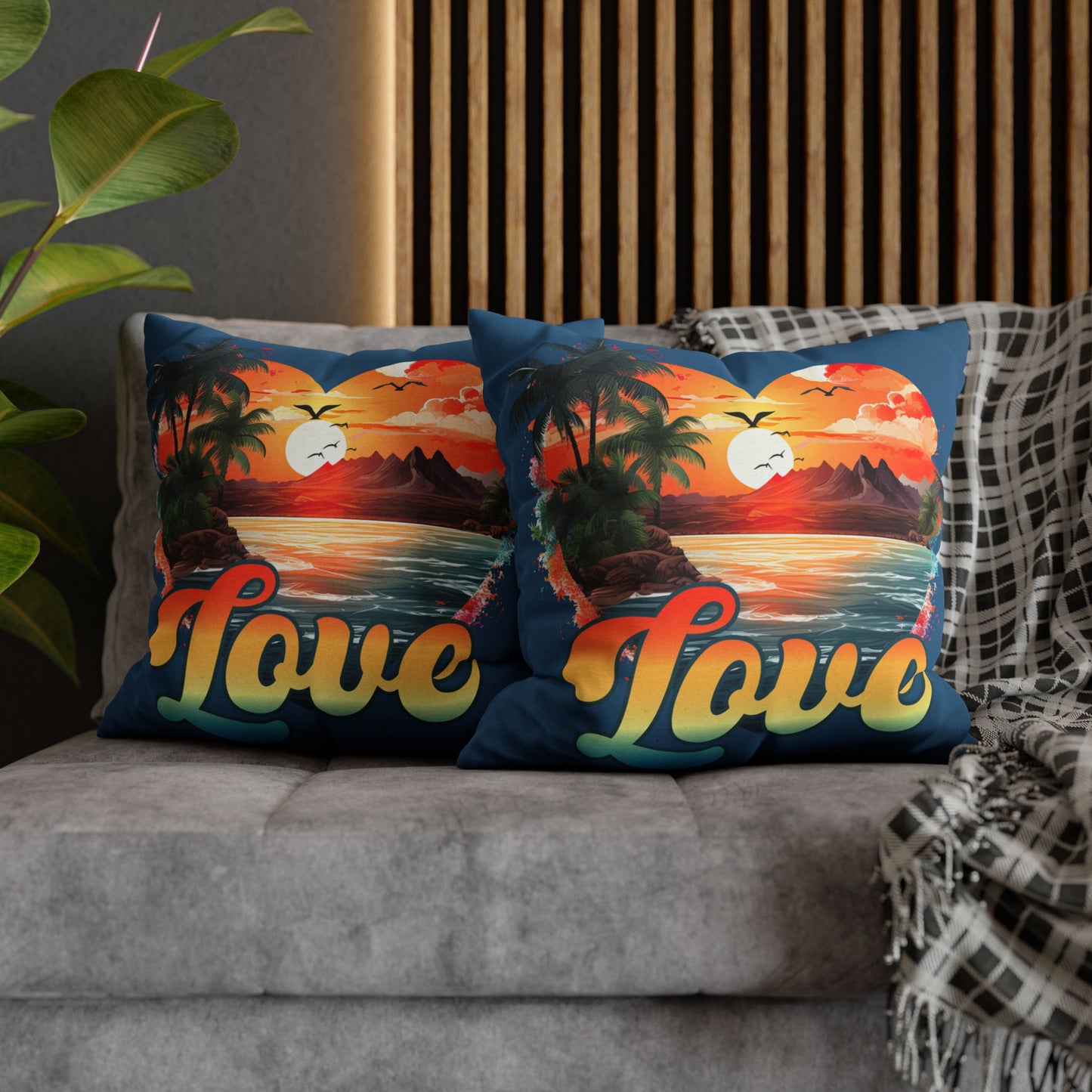 Two decorative 20" x 20" blue pillows with a sunset heart design and 'love' text on a gray couch.