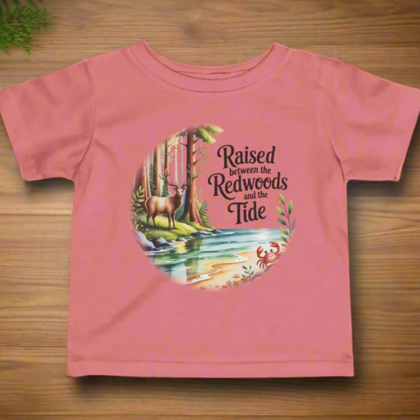 Pink t-shirt with nature-themed graphic and text on a white background