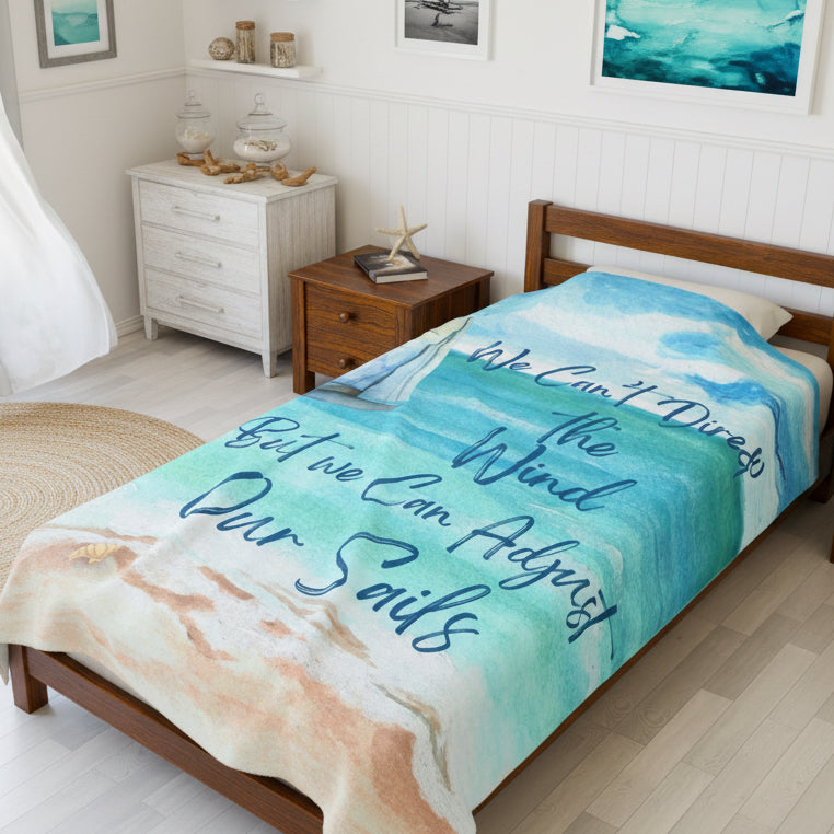 60" x 80" Blanket with ocean scene with sailboat sailing from coast with slogan "We Can't Direct the Wind But we Can Adjust Our Sails".