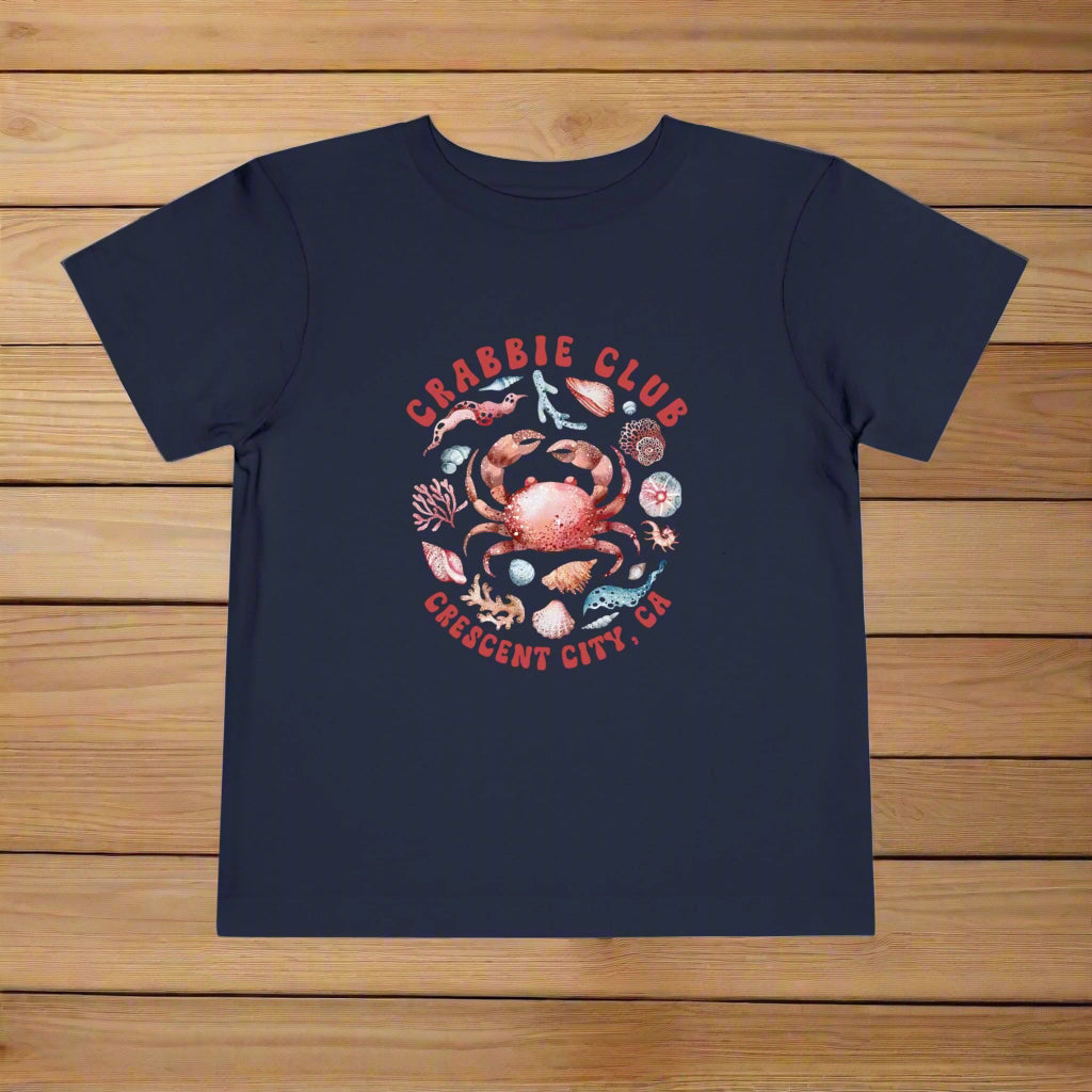 Navy Toddler t-shirt with the phrase “Crabbie Club Crescent City, CA” and a playful cartoon crab graphic.