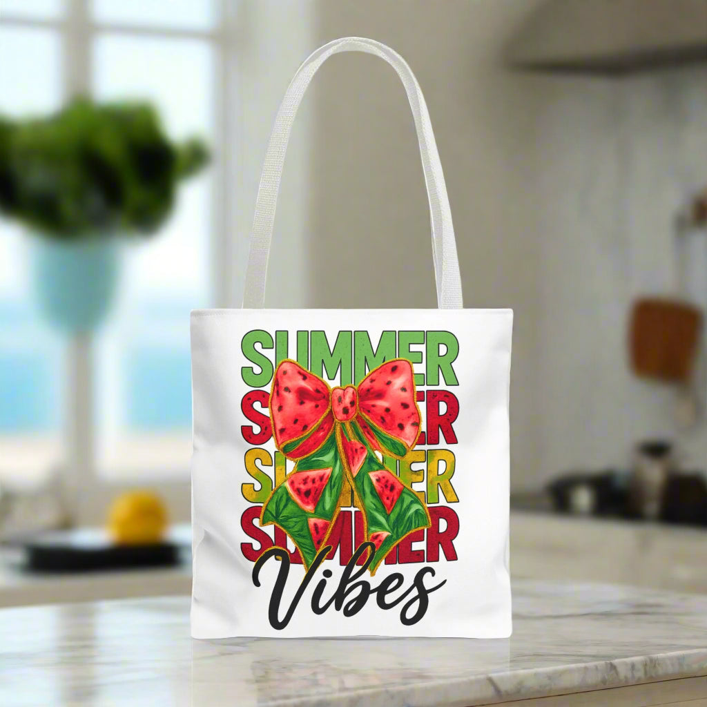 White tote bag with the word "Summer" repeated in green, red, and yellow, featuring a coquette-style bow, watermelon illustrations, and the word "Vibes" underneath.