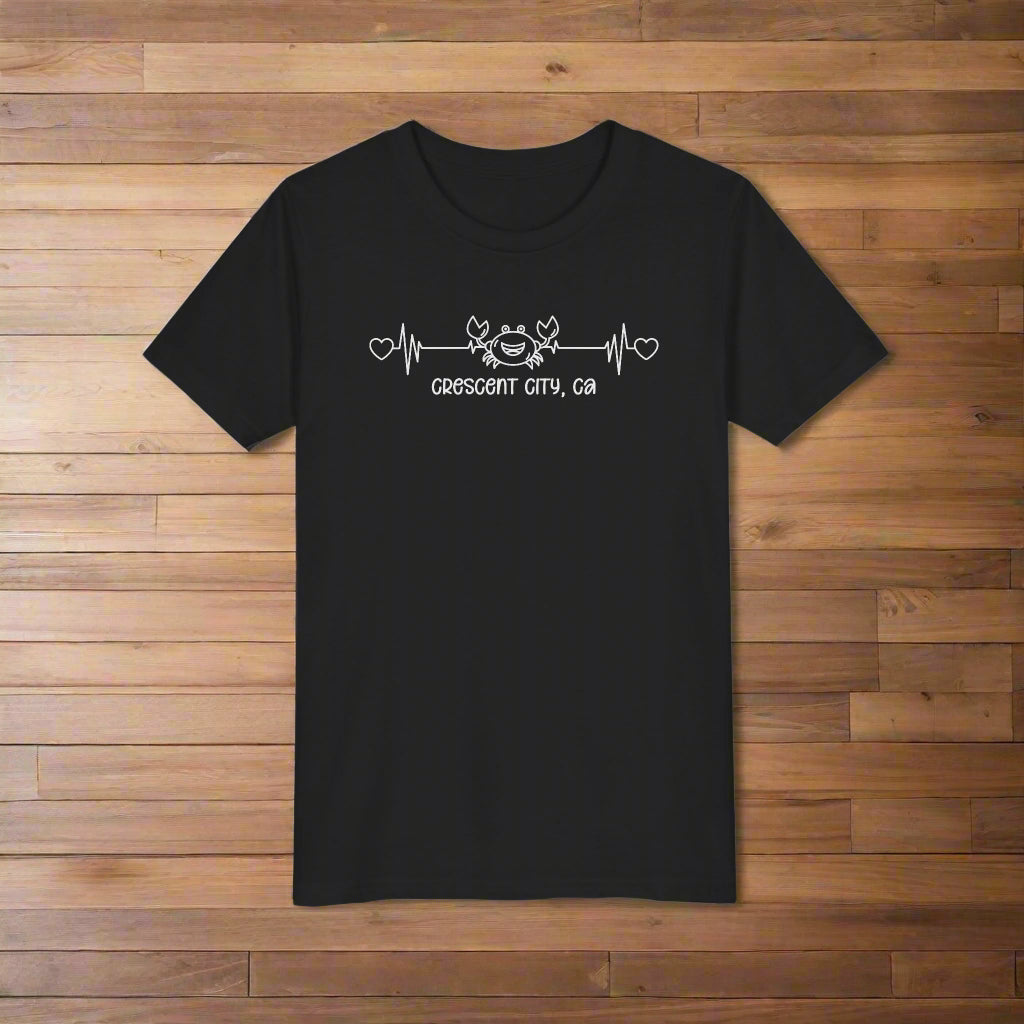 Black Child t-shirt with a smiley crab on a heartbeat line with hearts at both ends and “Crescent City, CA” underneath the design.