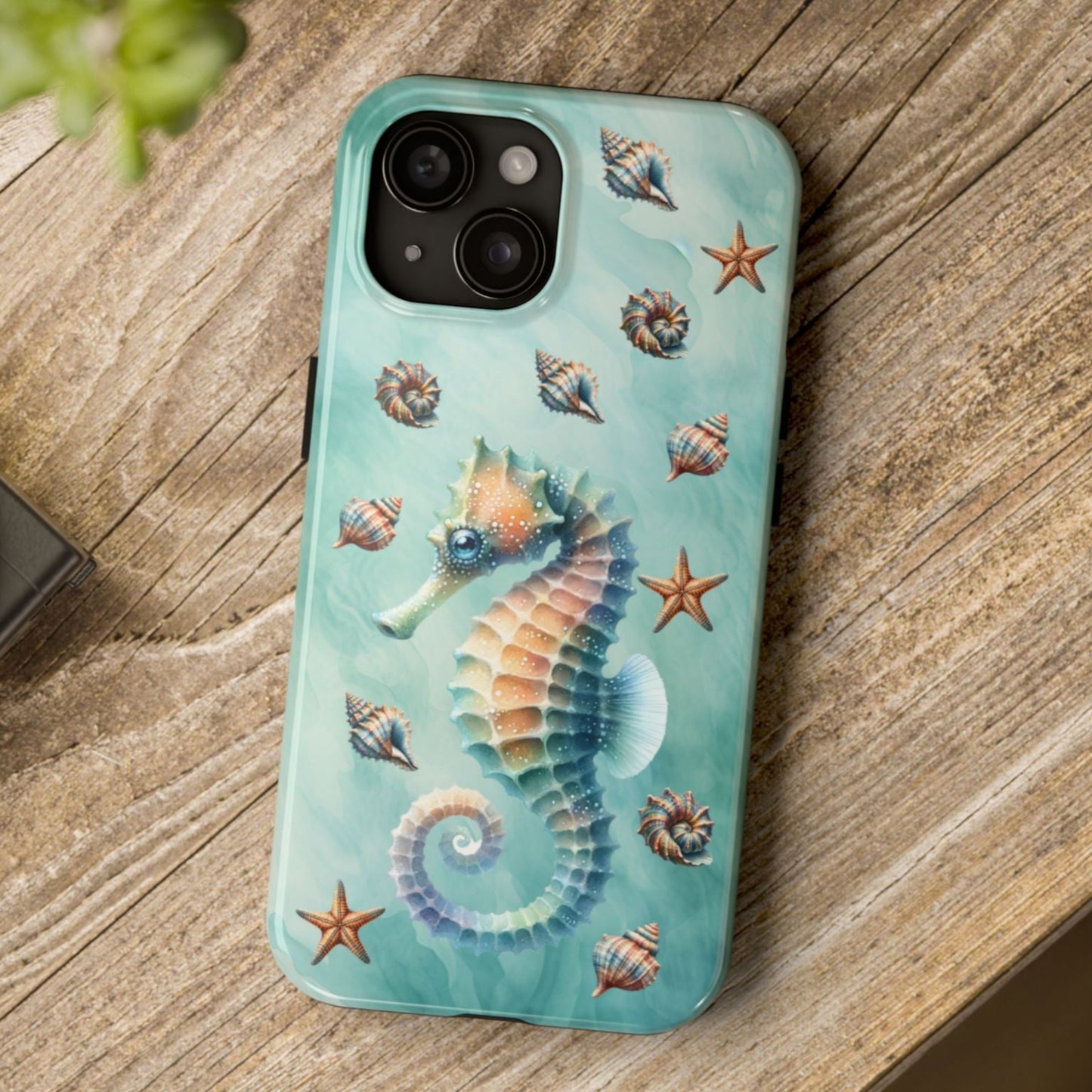 Phone case with seahorse design on a wooden surface