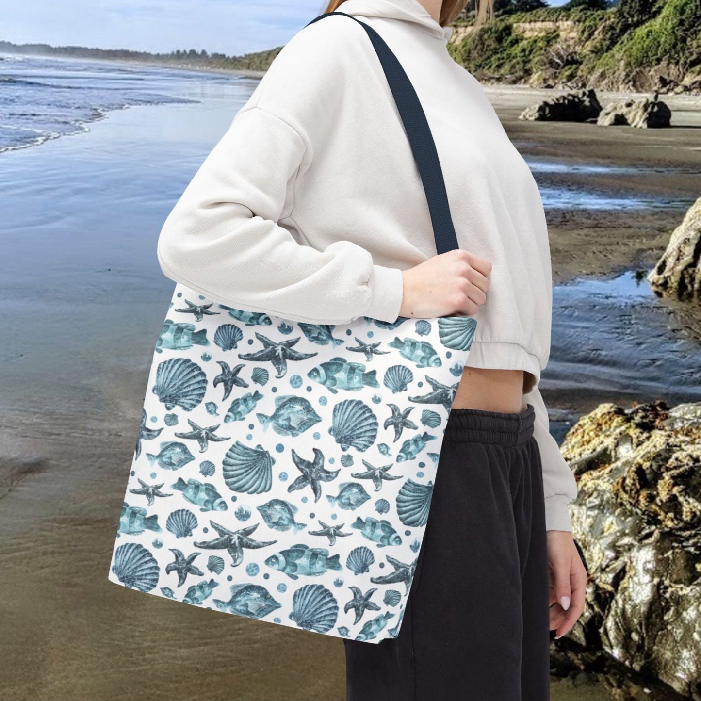 16" x 16" Tote bag with blue strap and an all-over blue seashell, starfish, and fish pattern on a white background with white handles.