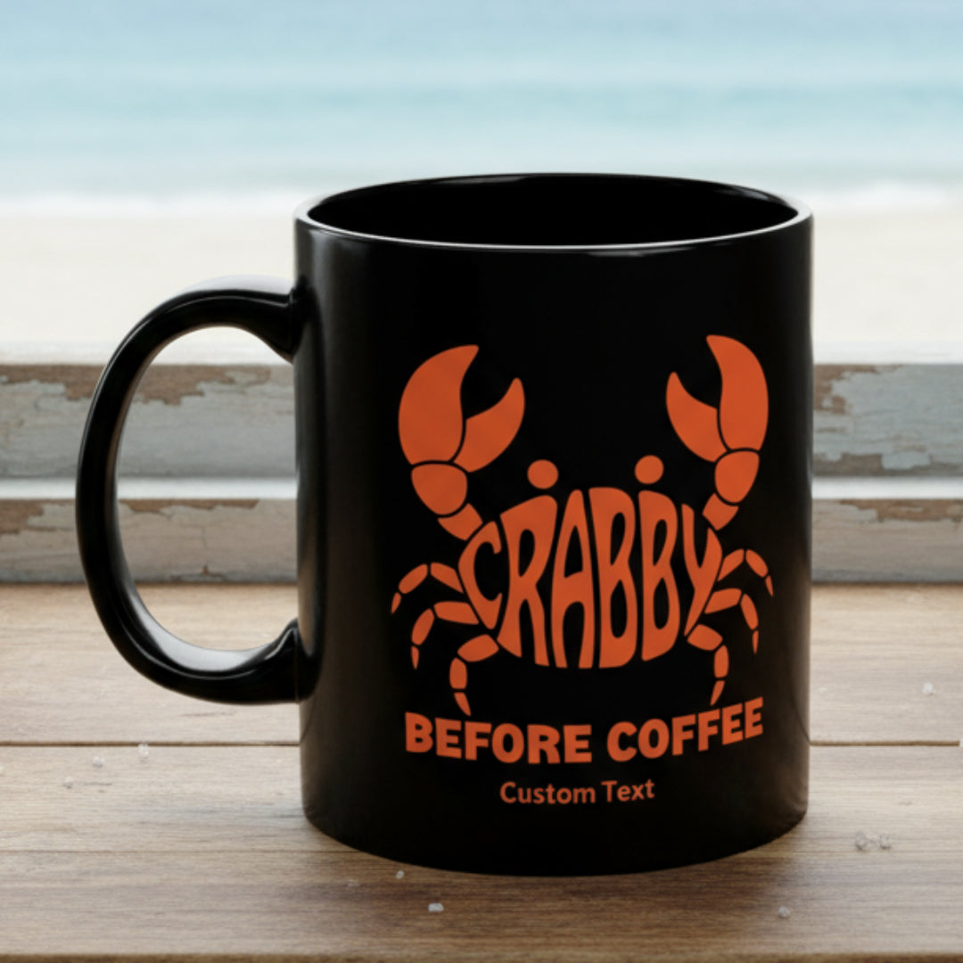 Black mug with orange crab graphic and text Crabby Before Coffee that can be personalized.