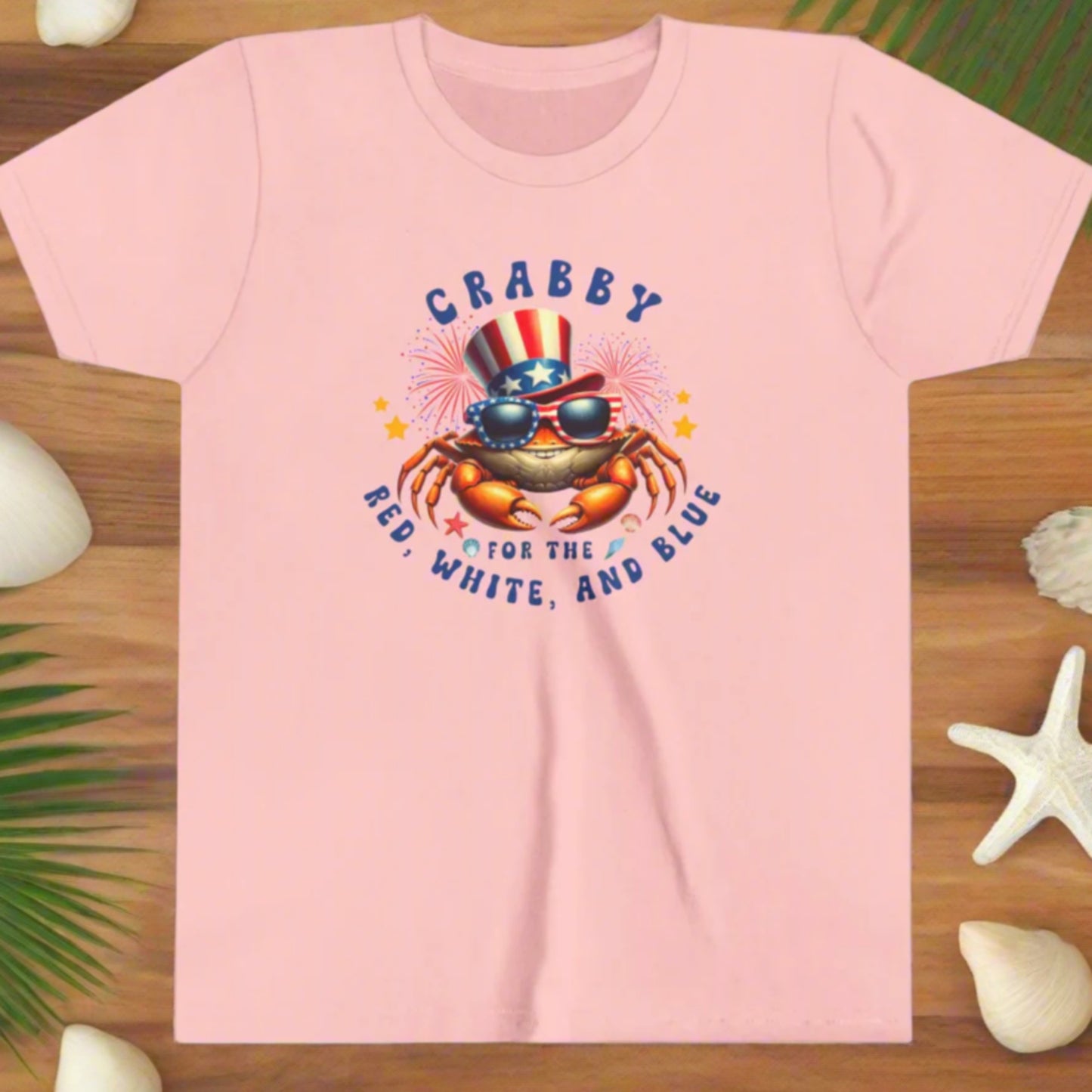 Pink t-shirt with a crab graphic and text on a white background
