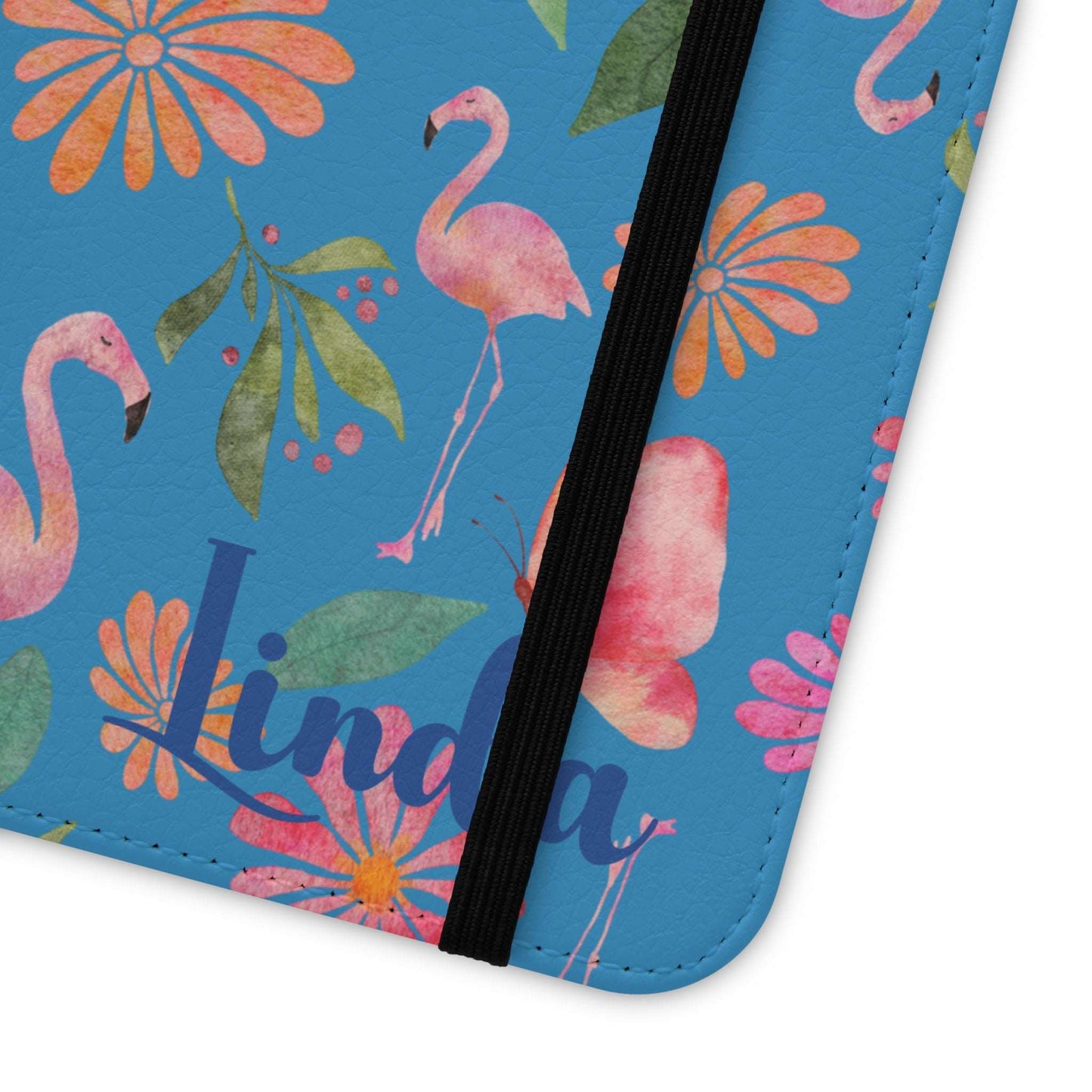 Close-up of corner stitching of flip phone case with flamingo and floral design on a blue background and personalized with name.
