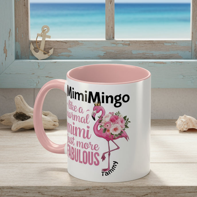 Mug with pink interior and handle, featuring a flamingo graphic and text on a white background.