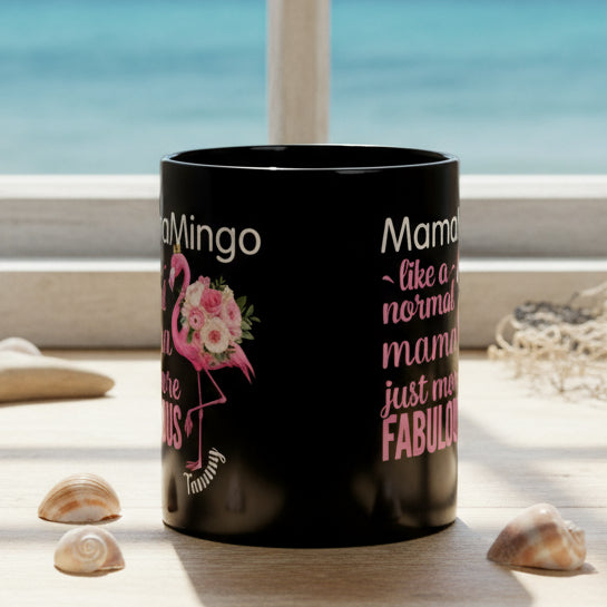 Black mug with pink flamingo design and text on a white background