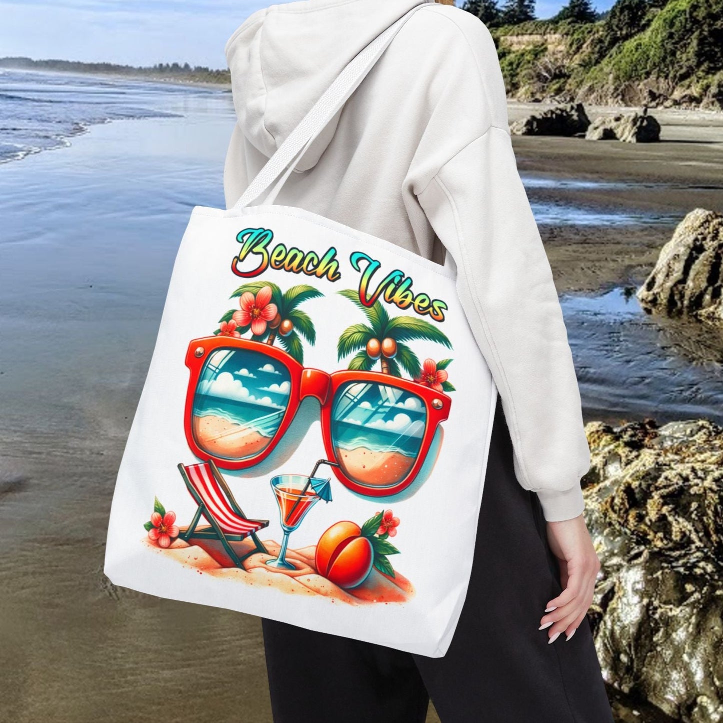 White 18" x 18" Tote bag featuring sunglasses with ocean and beach scene reflections, palm trees coming out of the glasses, a beach chair and cocktail on the sand, with the phrase "Beach Vibes" in a retro rainbow gradient font.