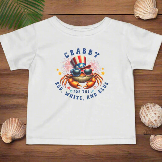 White Infant t-shirt with a crab wearing an American flag top hat surrounded by fireworks and seashells with the phrase “Crabby for the Red, White, and Blue.”