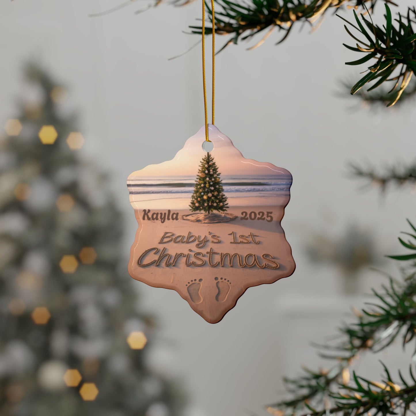 Decorative ornament for 'Kayla's Baby's 1st Christmas' hanging on a tree branch with a blurred festive background.
