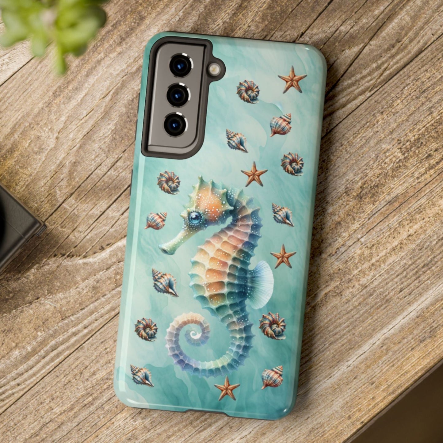 Phone case with seahorse design on a wooden surface