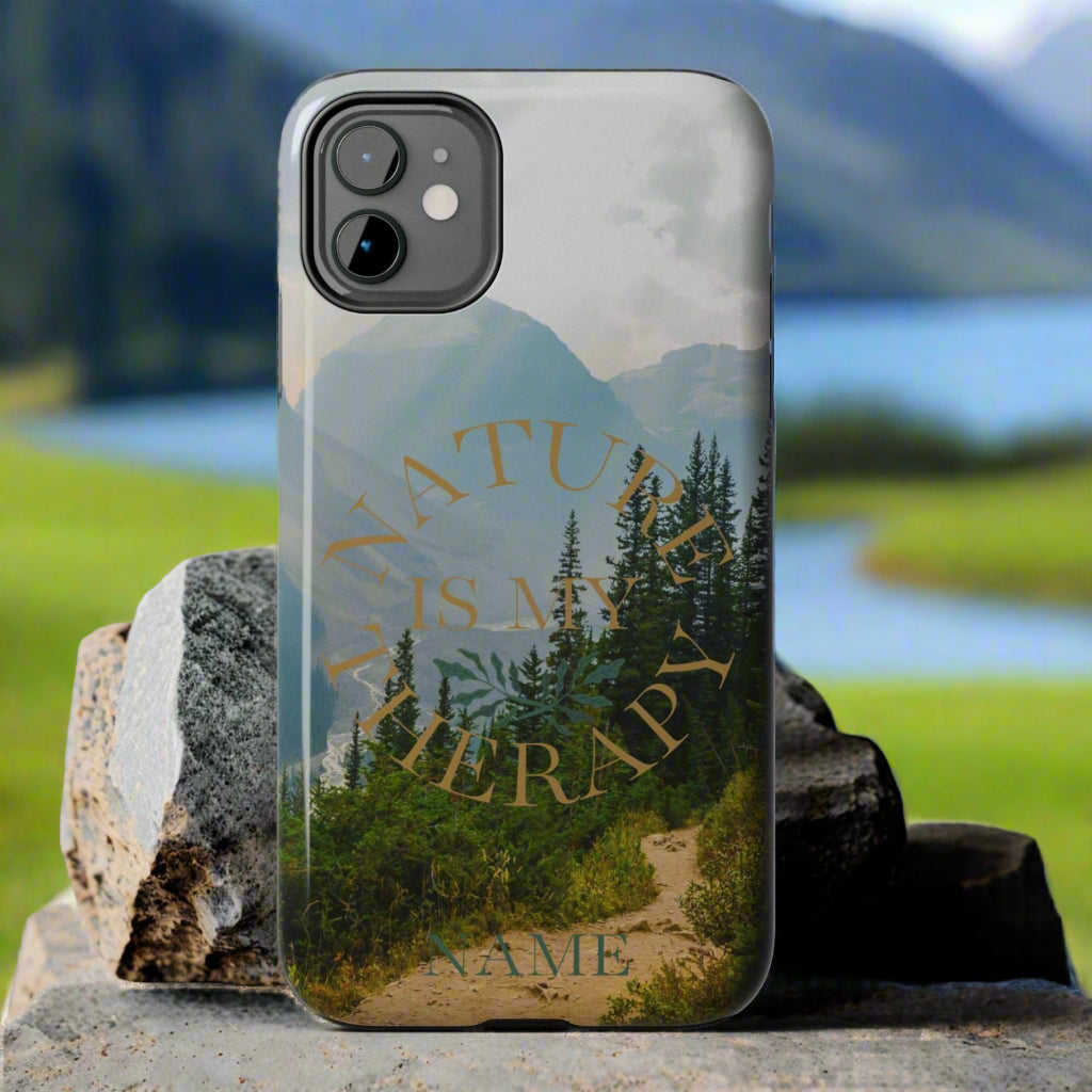 Phone case with nature design and text on a rock against a gray background