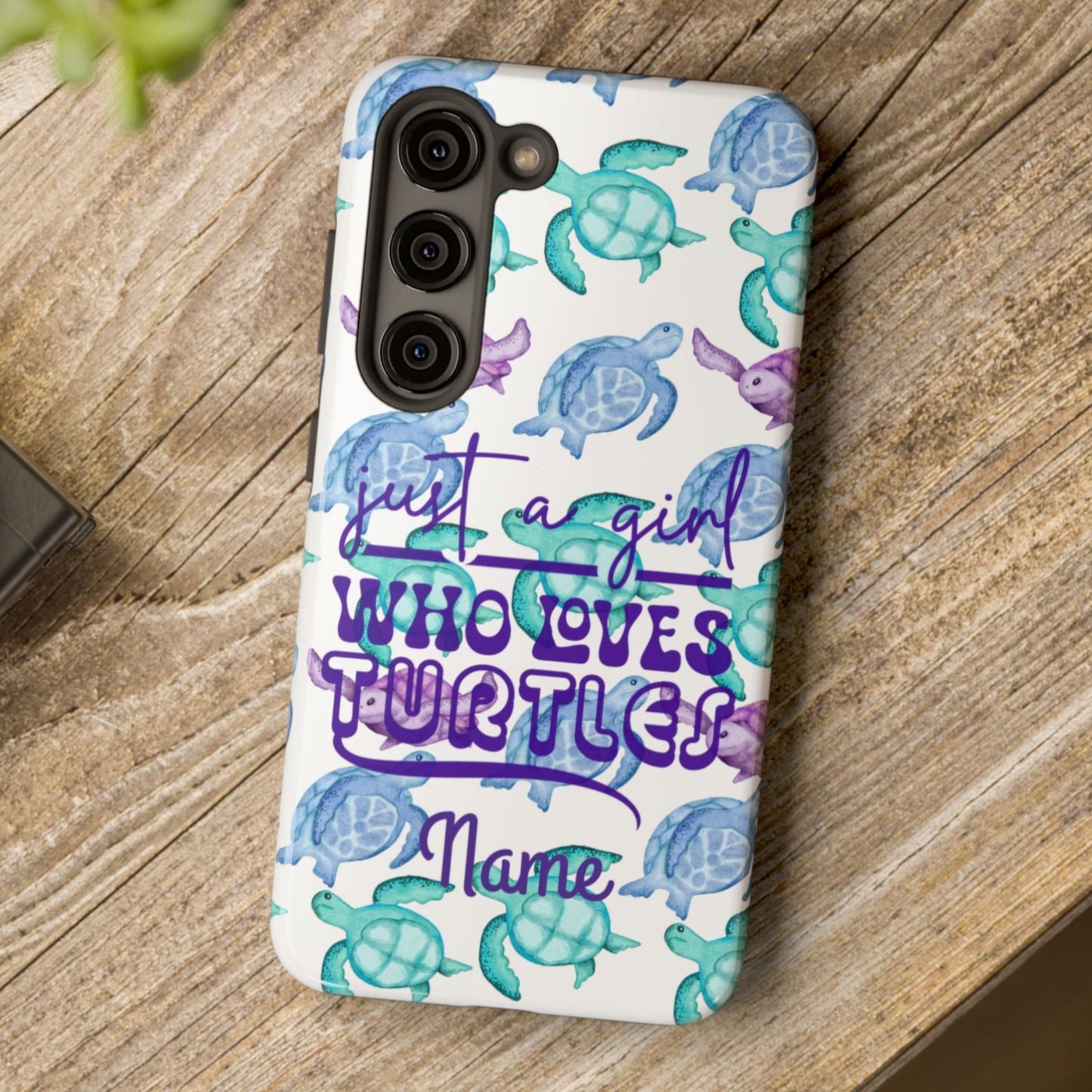 Phone case with sea turtle design and text on a wooden surface