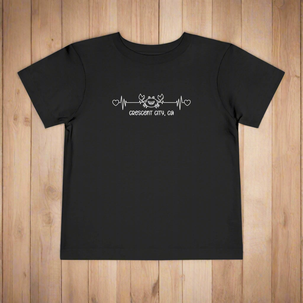 Black Toddler t-shirt featuring a smiley crab on a heartbeat line with hearts at both ends and the text “Crescent City, CA” underneath.
