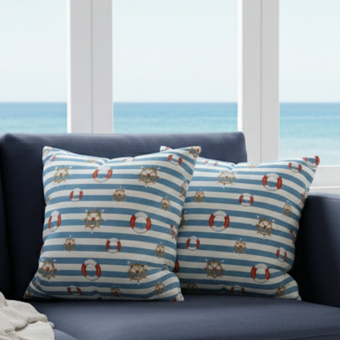 Two decorative pillows with nautical patterns on a gray sofa.