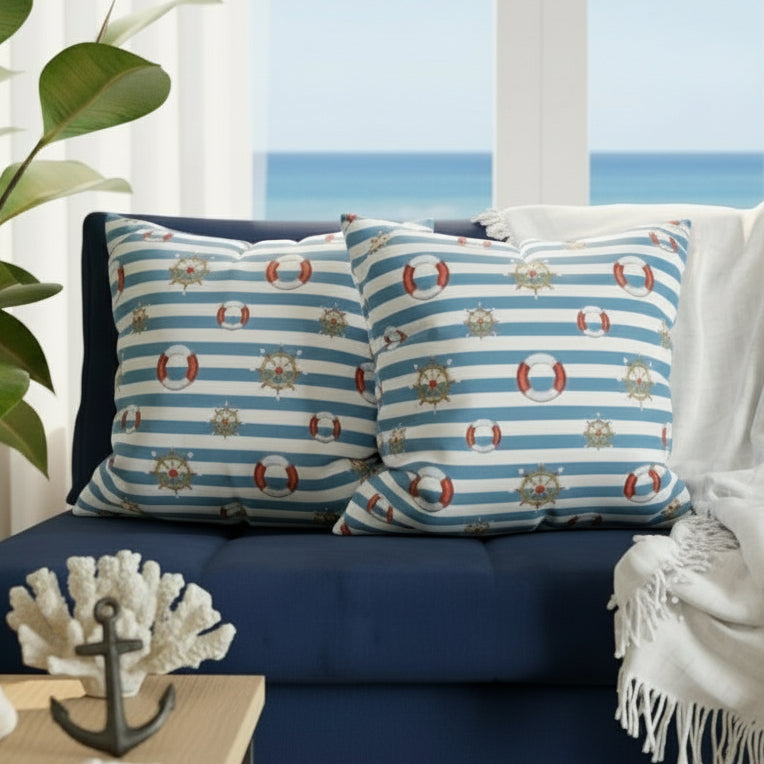 Nautical-themed pillows on a gray sofa with a plant in the background