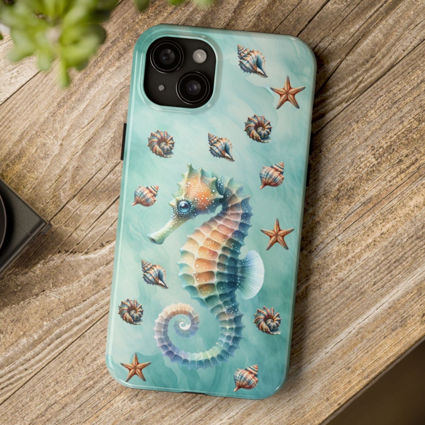 Phone case with seahorse design on a wooden surface