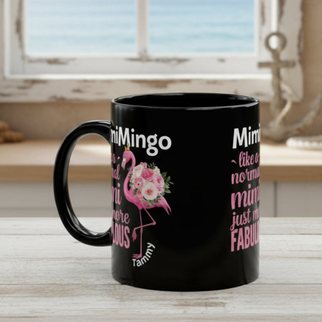 Black mug with pink flamingo design and text on a white background