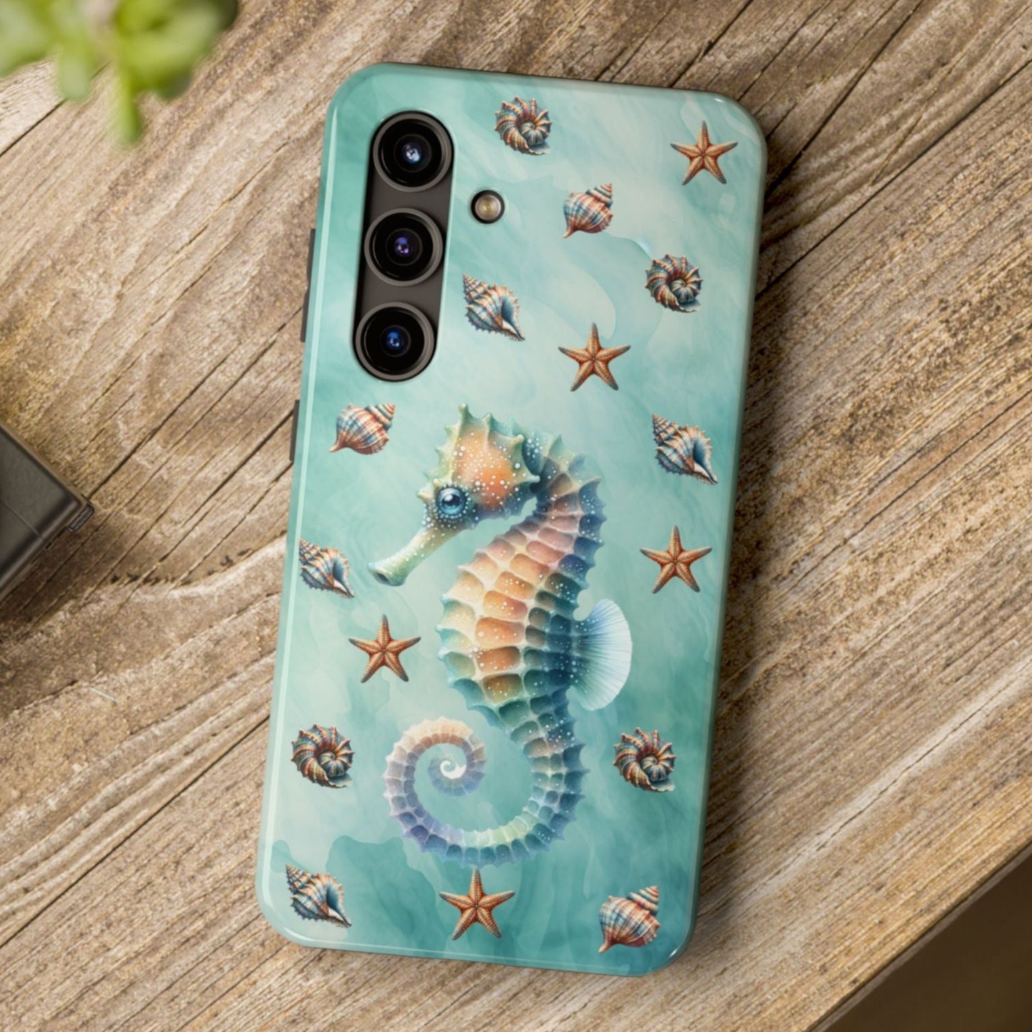 Phone case with seahorse design on a wooden surface