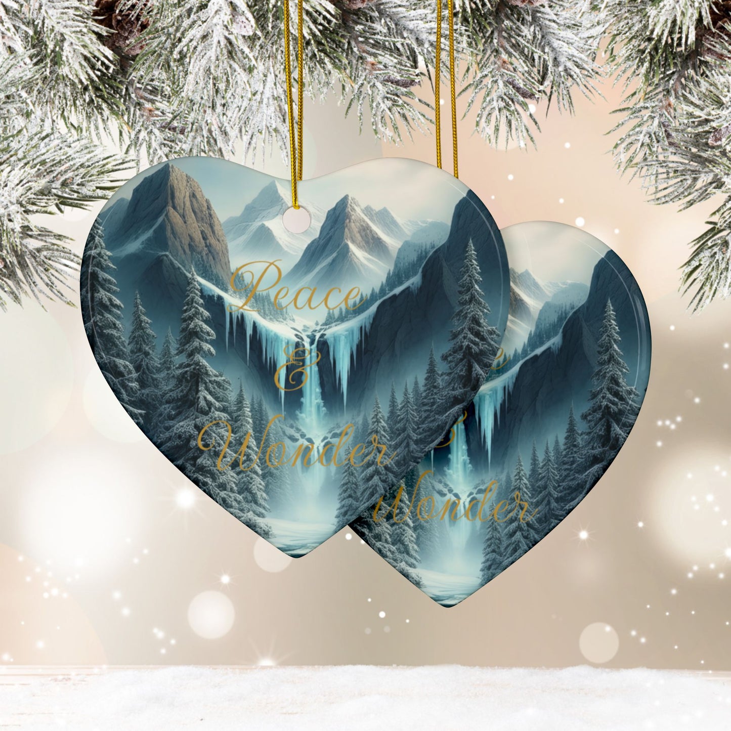 Heart-shaped Christmas ornament with mountain and forest design, featuring 'Peace & Wonder', against a snowy background.