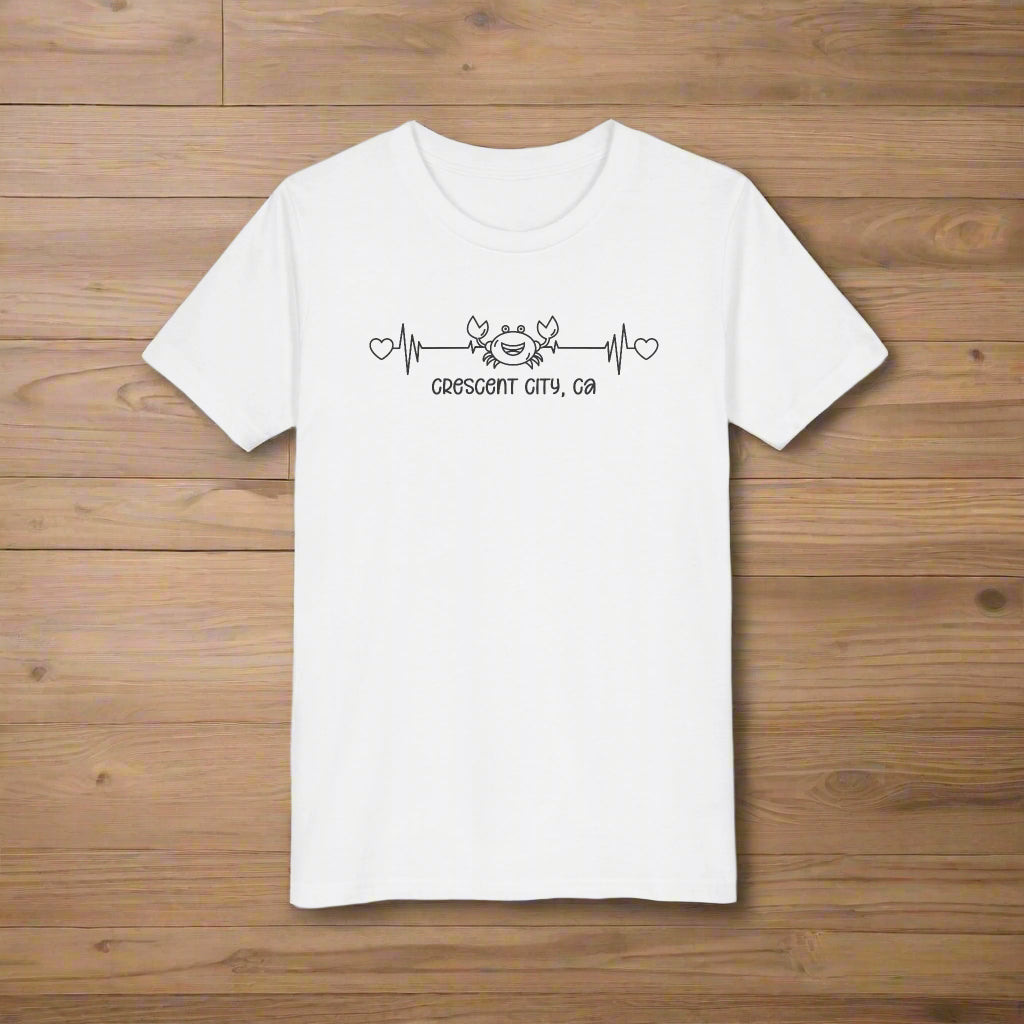 White Child t-shirt with a smiley crab on a heartbeat line with hearts at both ends and “Crescent City, CA” underneath the design.