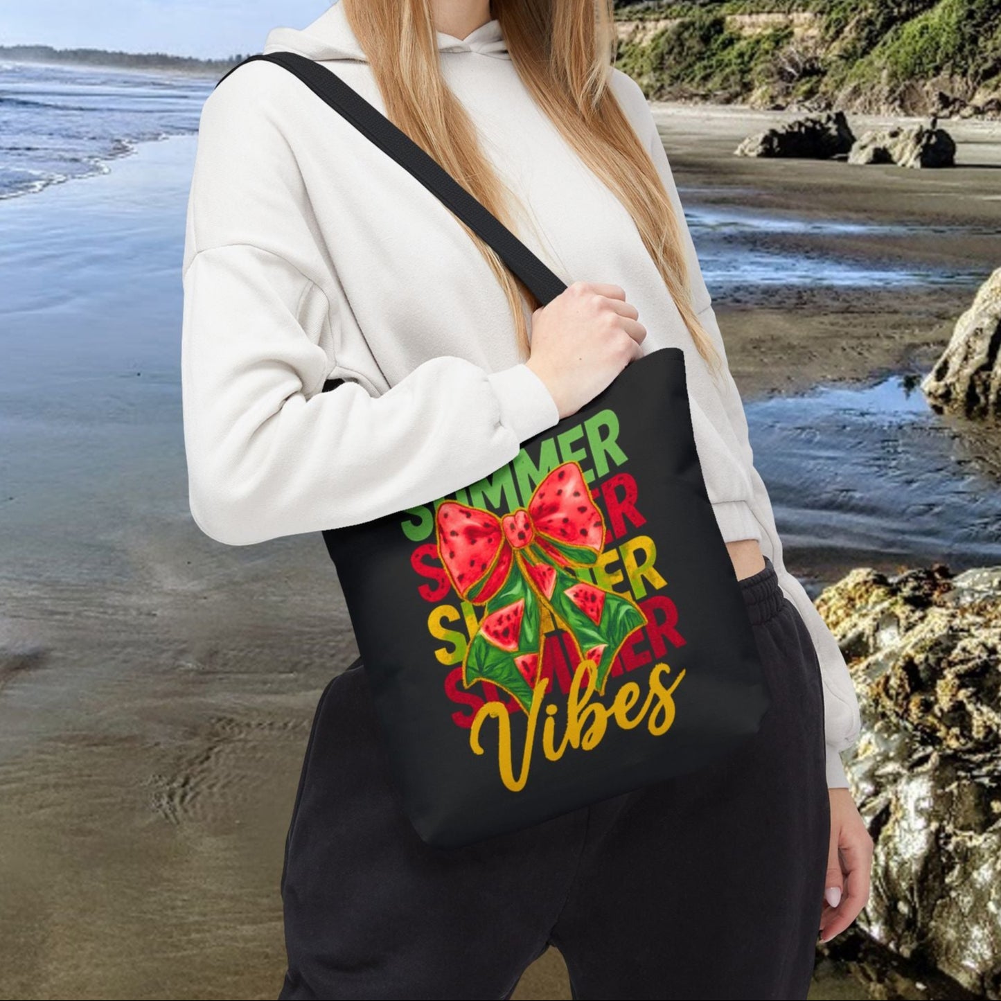 Black 13" x 13" tote bag with the word "Summer" repeated in green, red, and yellow, featuring a coquette-style bow, watermelon illustrations, and the word "Vibes" underneath.