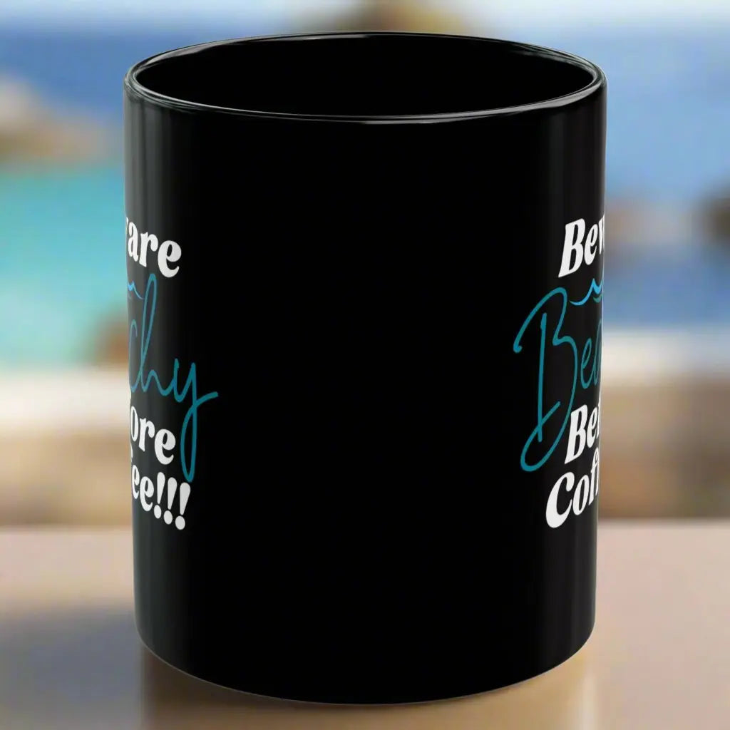 Side view of White coffee mug that says Beware Beachy Before coffee with wave image.