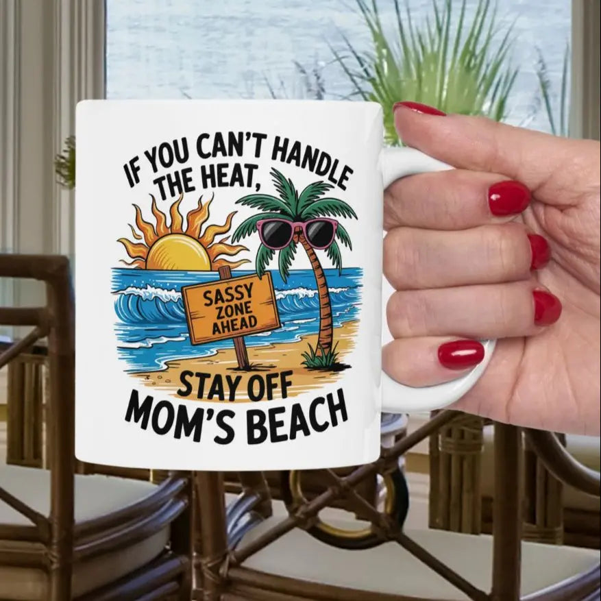 A white 11 oz mug with a beach scene and a beach sign that says Sassy Zone Ahead with the text If You Can't Handle the Heat Stay Off Mom's Beach.
