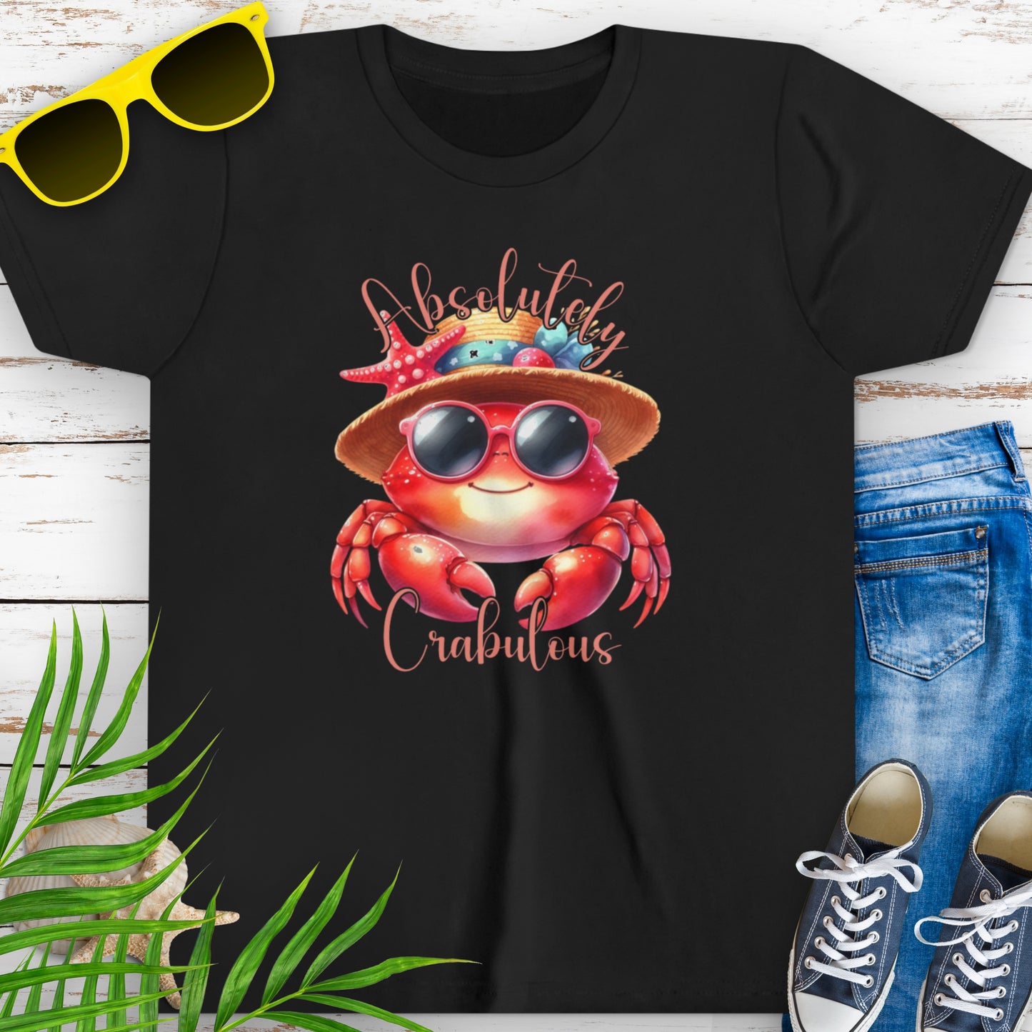 Black t-shirt with a cartoon crab wearing sunglasses and a beach hat decorated with seashells, with the text “Absolutely Crabulous.”