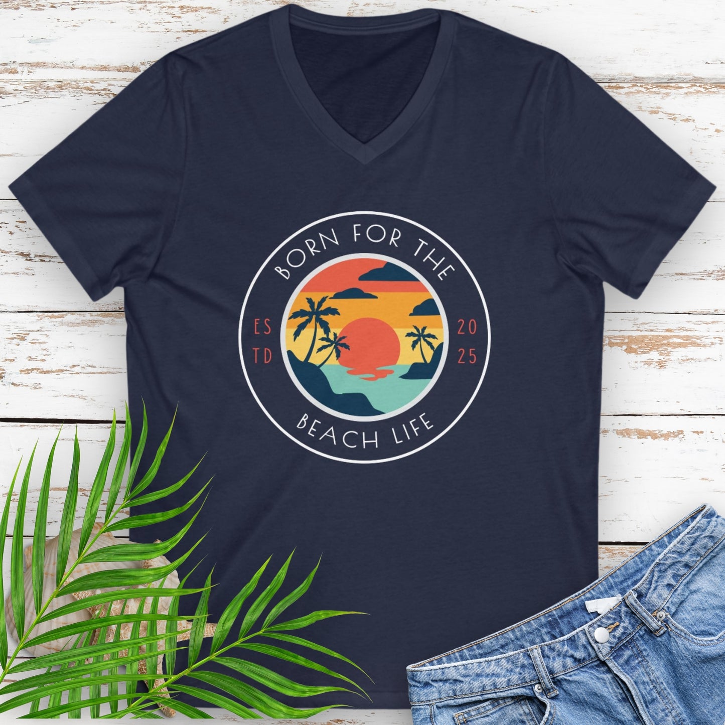 Navy v-neck blue t-shirt with circle design with a beach scene and the text “Born for the Beach Life.