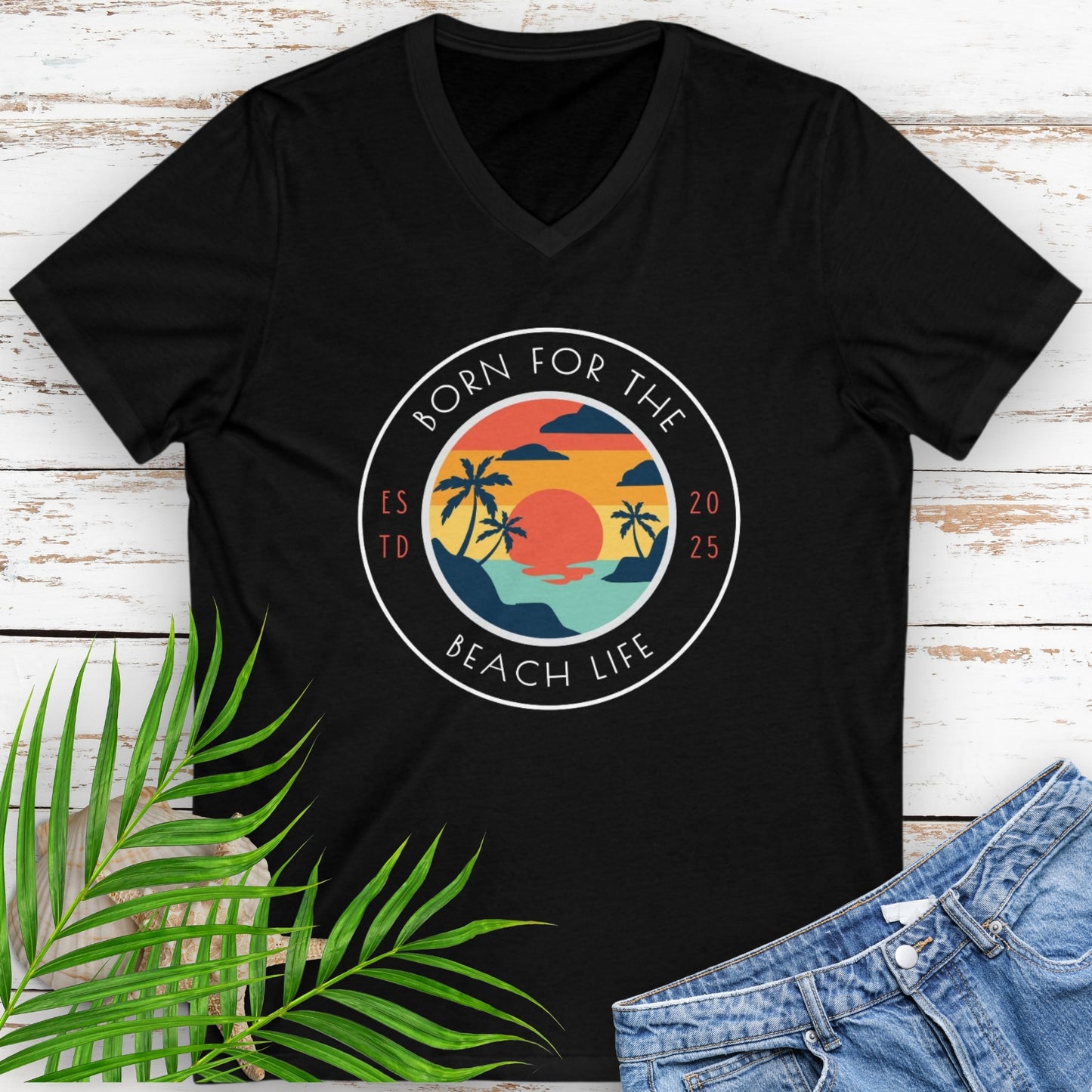 Black v-neck t-shirt with circle design with a beach scene and the text “Born for the Beach Life.