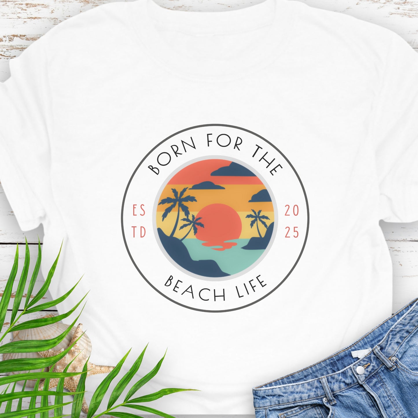 White t-shirt with circle design with a beach scene and the text “Born for the Beach Life.