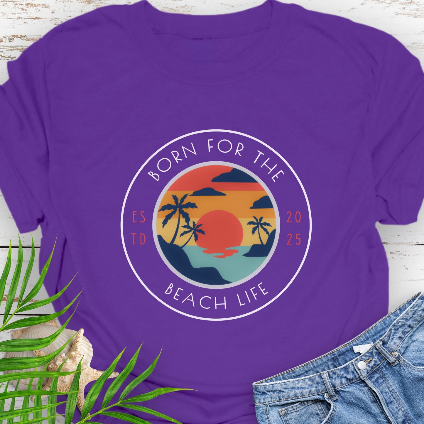 Purple t-shirt with circle design with a beach scene and the text “Born for the Beach Life.