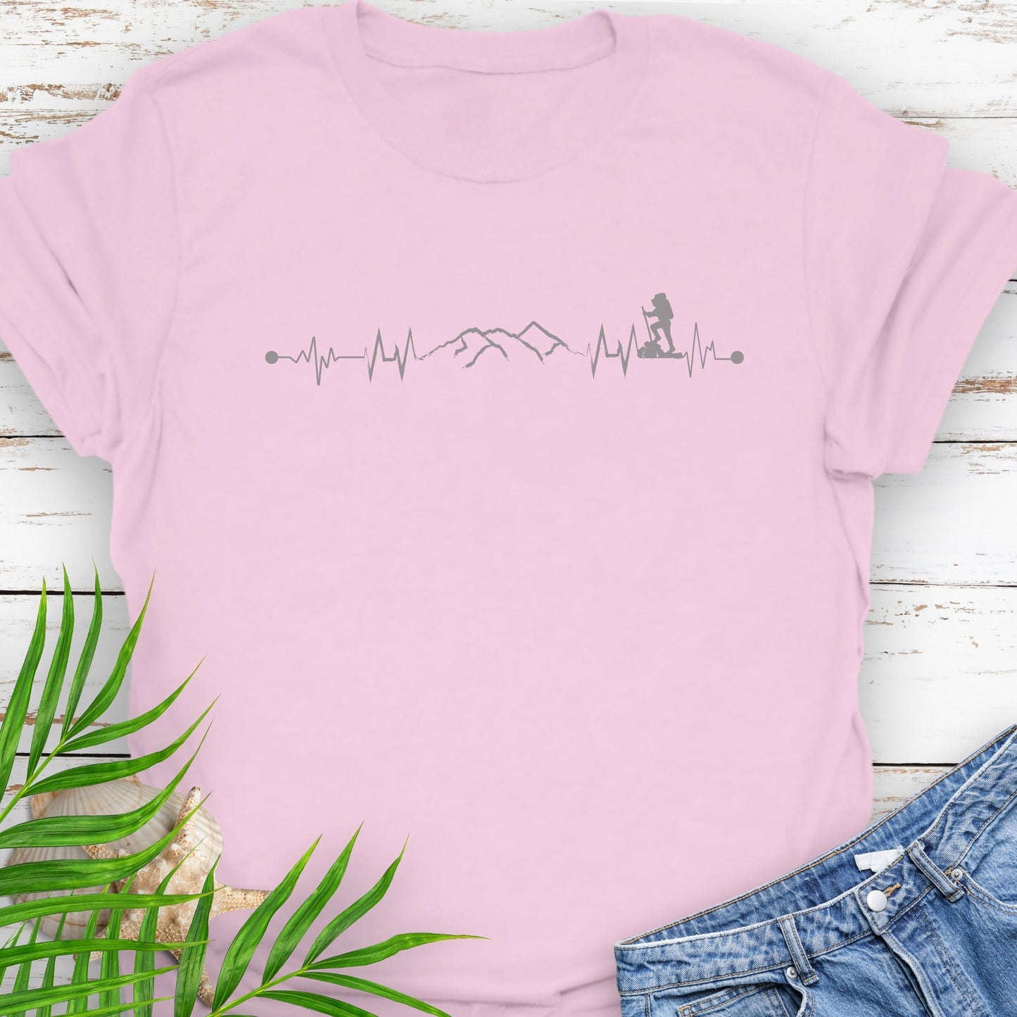 Pink t-shirt with a heartbeat line with a mountain range and backpacker.