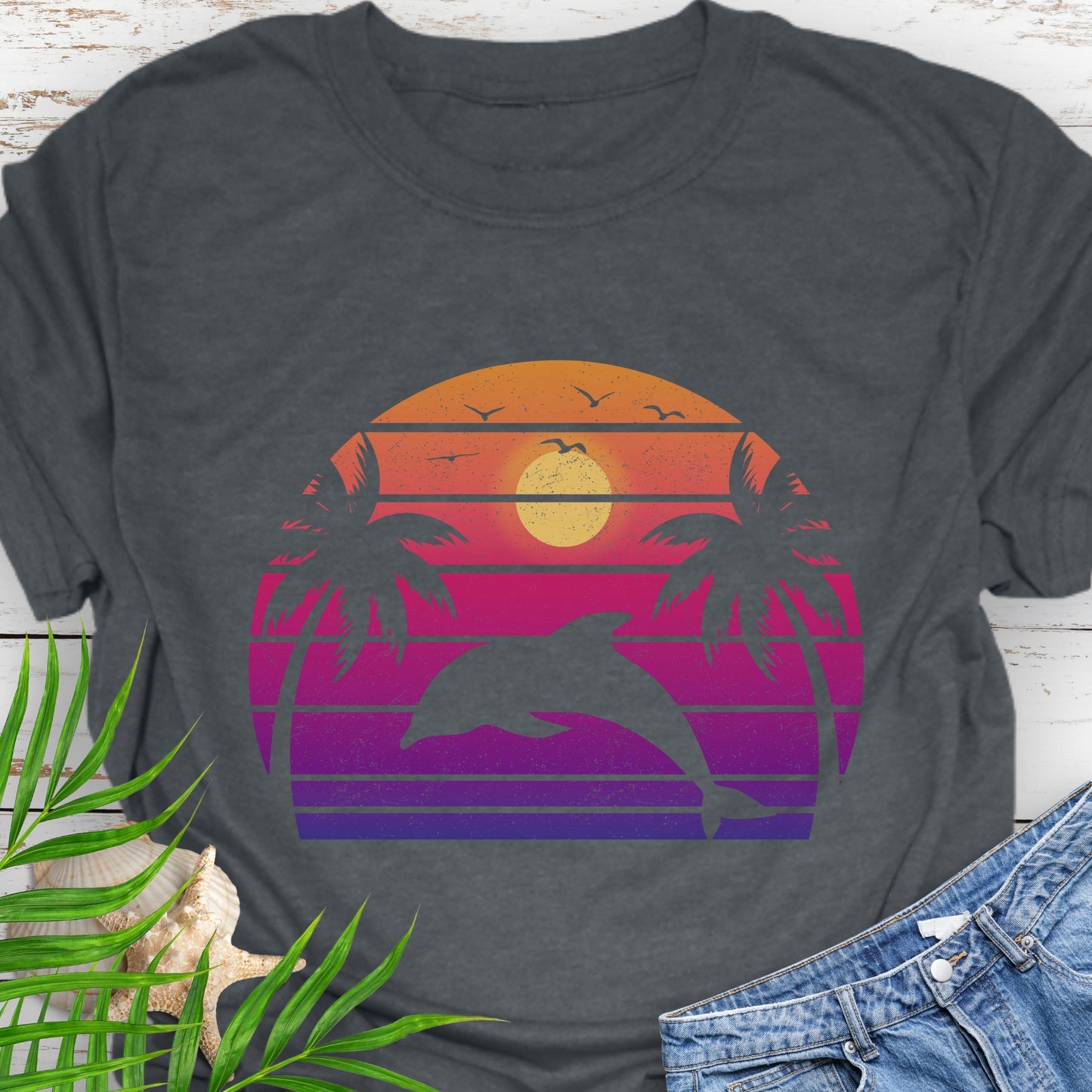 Gray T-shirt with a dolphin against a retro sunset and two palm trees.