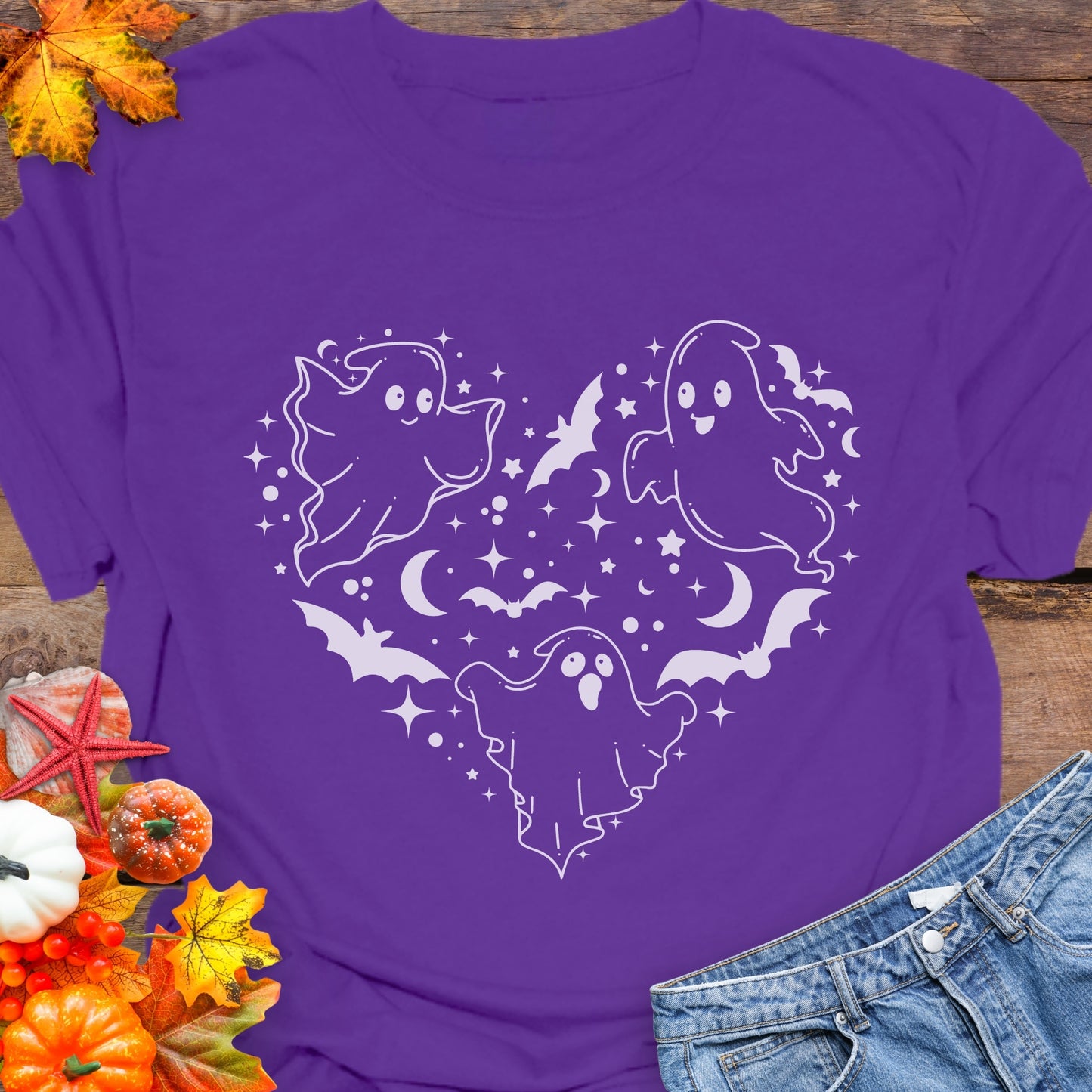 Purple unisex T-shirt with a design of white ghosts and black bats forming the shape of a heart.