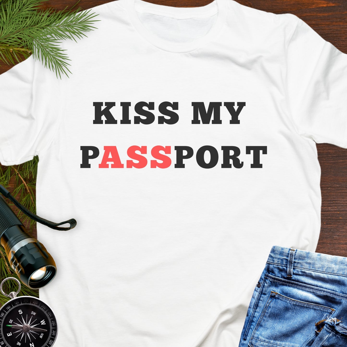 White t-shirt with the phrase “Kiss My Passport” where the letters “ASS” are highlighted.