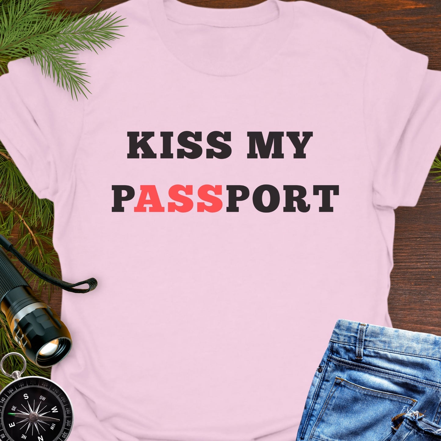 Pink t-shirt with the phrase “Kiss My Passport” where the letters “ASS” are highlighted.