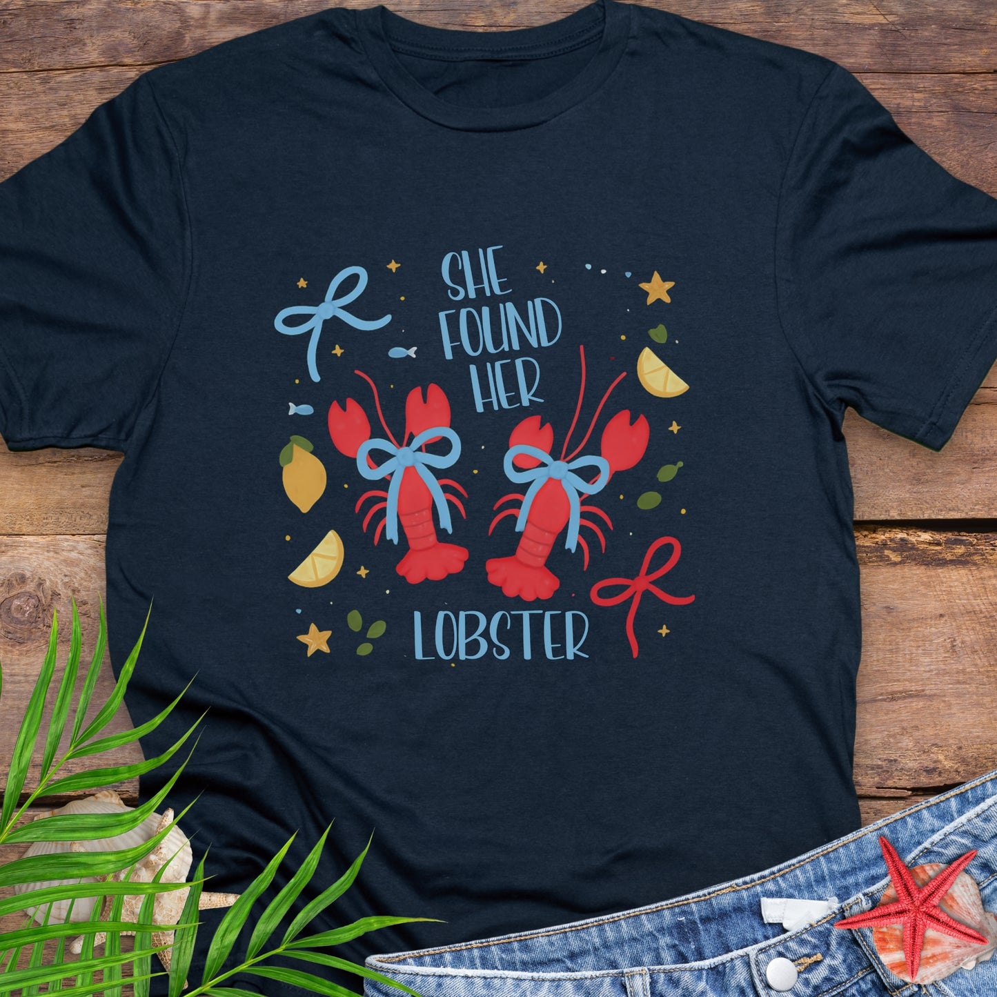 Navy Blue T-shirt with two lobsters and blue bows that says She Found Her Lobster.