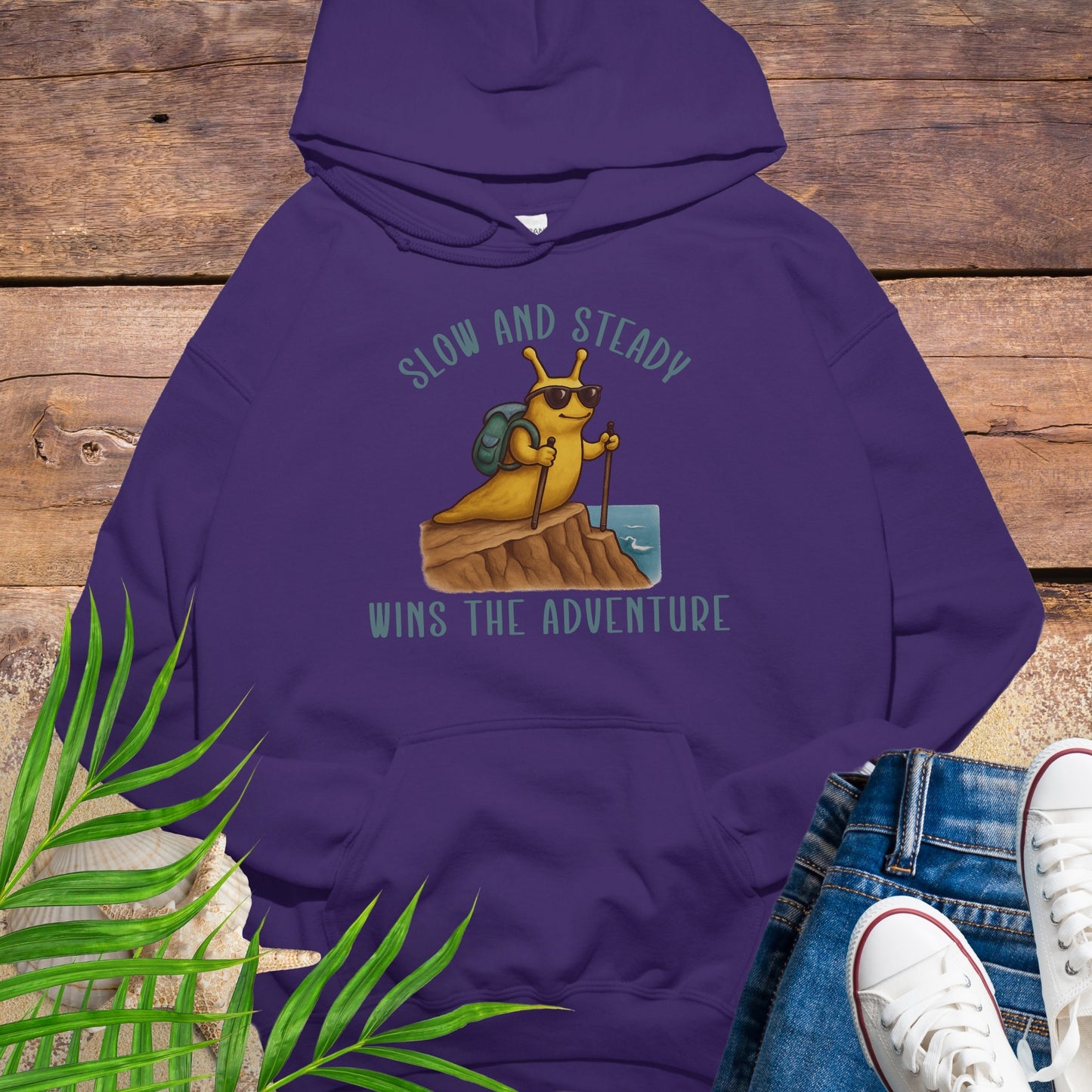 Purple hoodie with a bee graphic and text on a wooden surface