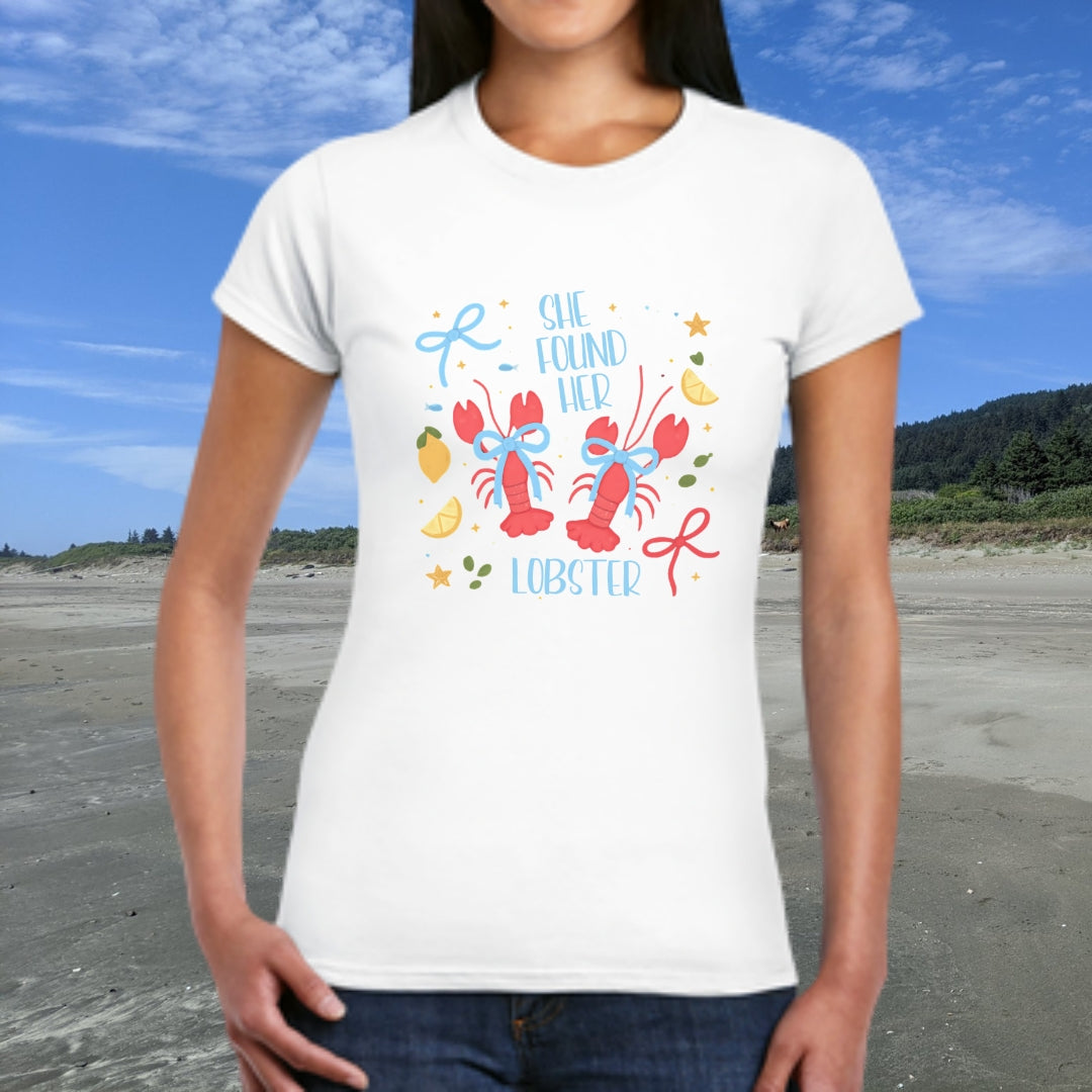Person wearing a white  woman's t-shirt with colorful lobster design and text She Found Her Lobster.