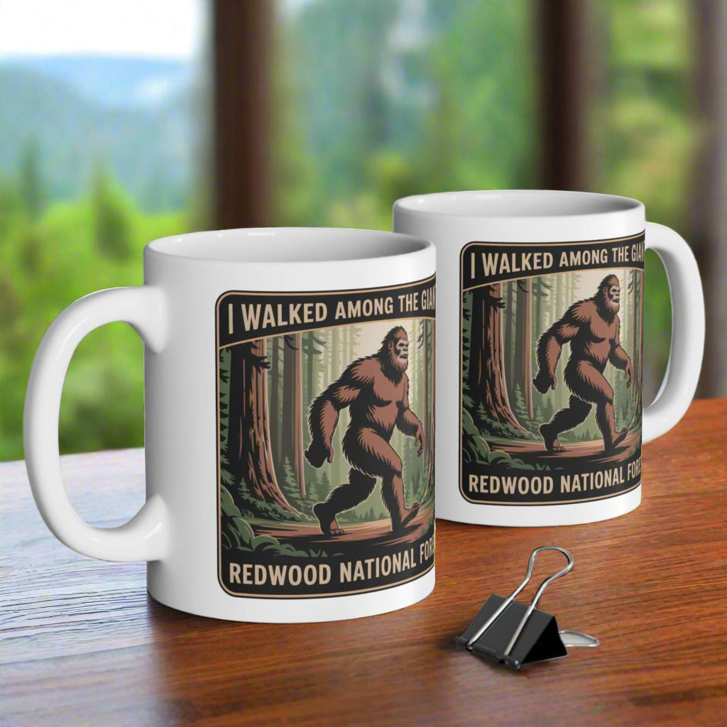 Two mugs with Bigfoot design on a desk with office items.