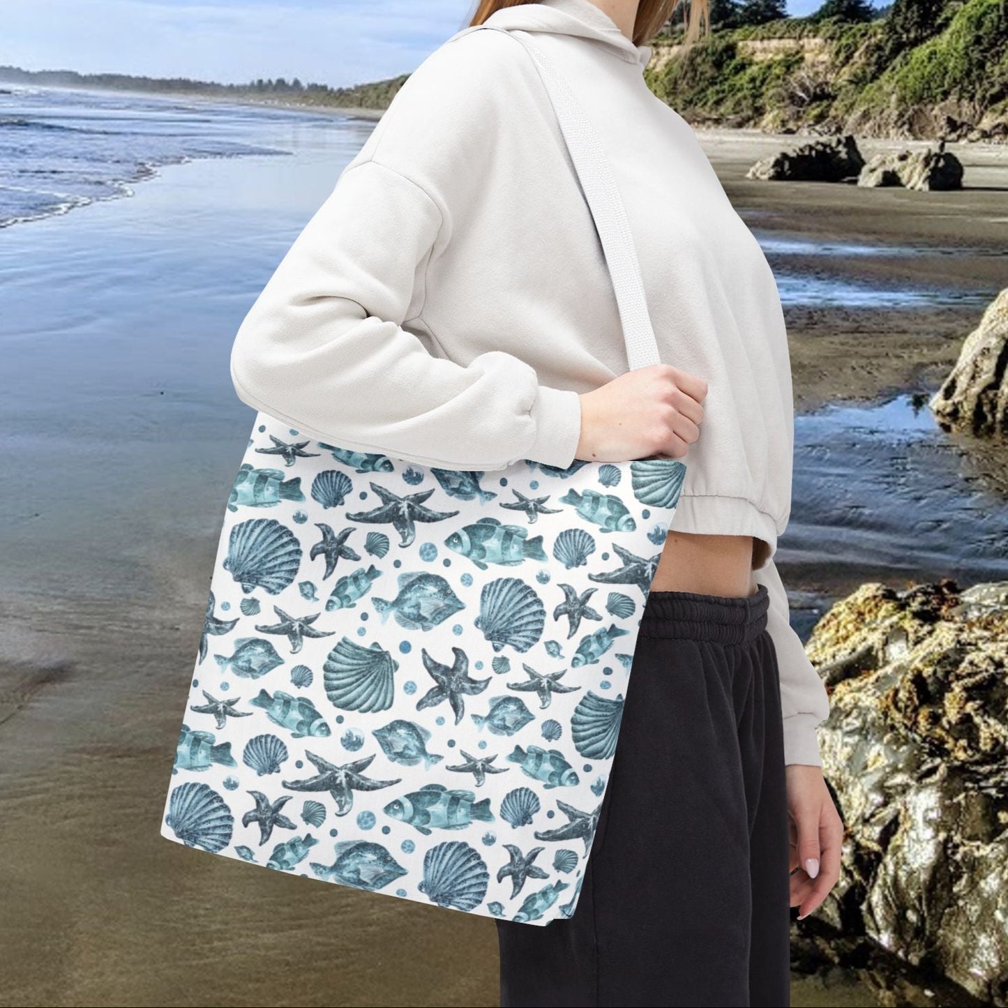 16" x 16" Tote bag with white strap and an all-over blue seashell, starfish, and fish pattern on a white background with white handles.