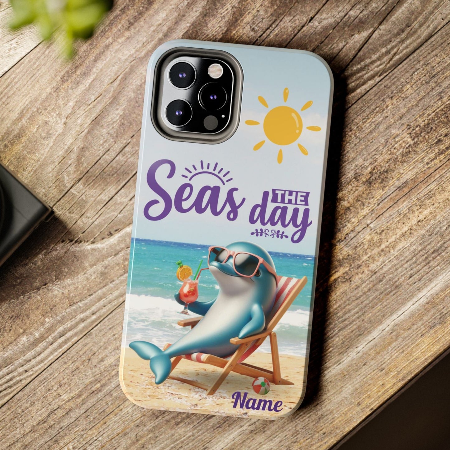 Seas the Day dolphin-themed phone case with personalized name, glossy finish, and beach-inspired design with a dolphin enjoying a cocktail during a sunny day on the beach with the phrase Seas the Day.