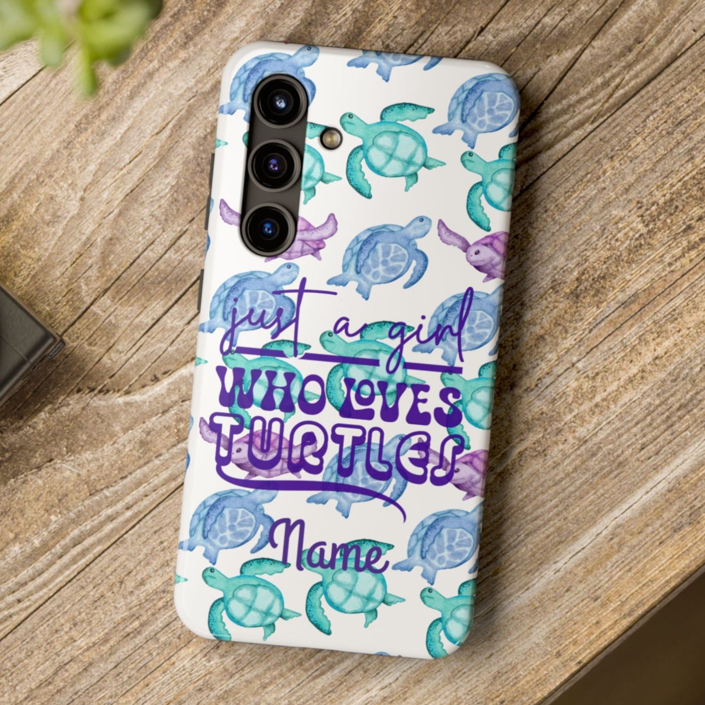 Phone case with sea turtle design and text on a wooden surface
