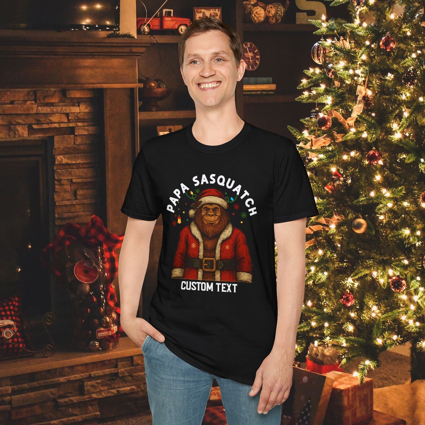 Person wearing a black t-shirt with a Papa Sasquatch wearing a Santa hat and suit with custom text.